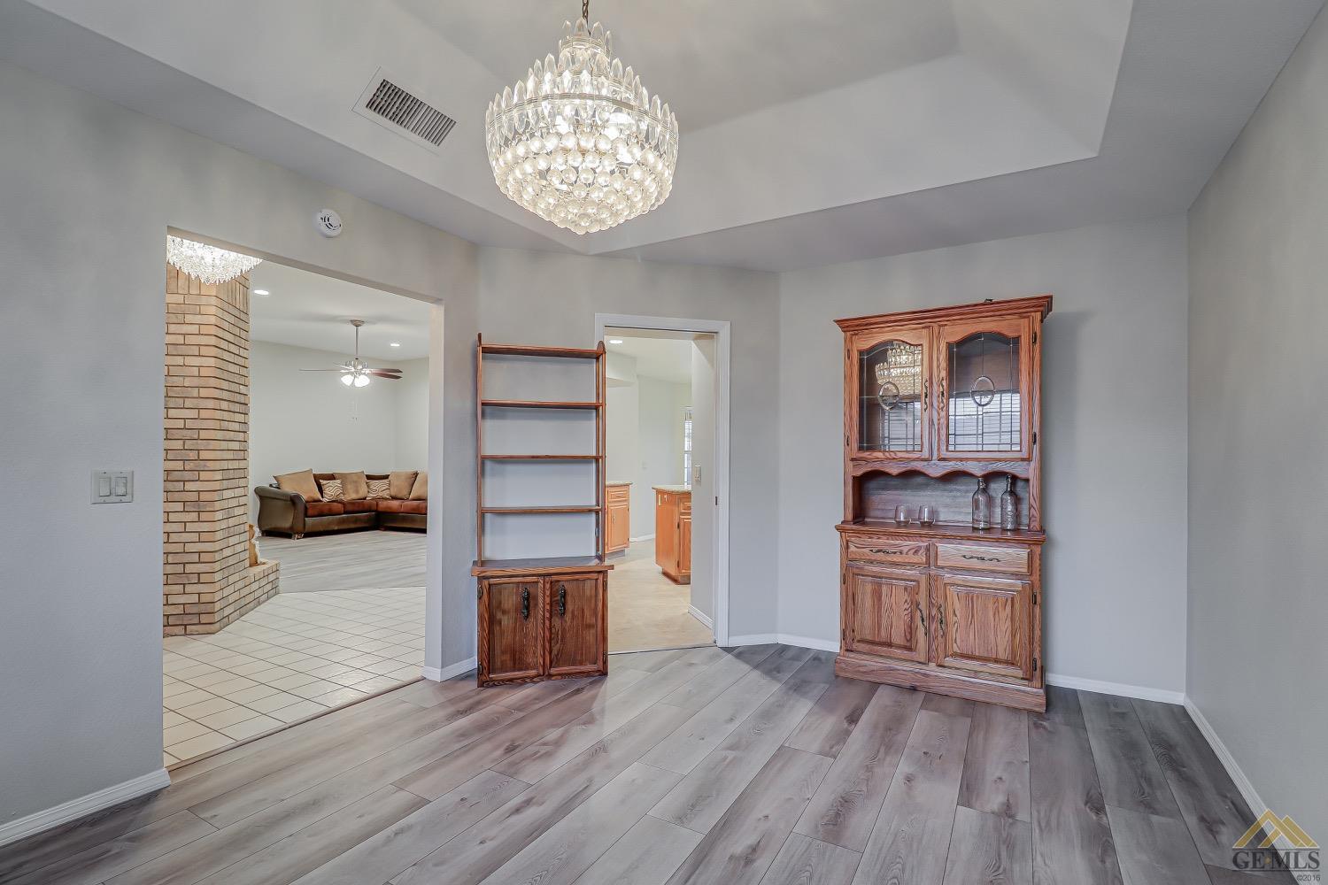 Undisclosed Address Bakersfield, CA 93314 - Photo 8 of 38 a view of a hallway with wooden floor and a chandelier