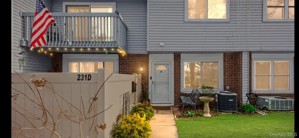 a front view of a house with a garden and chairs