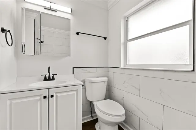 a bathroom with a toilet a sink and a window