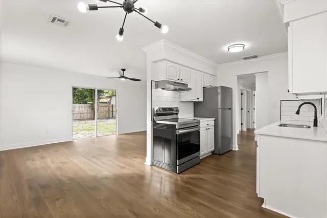 a kitchen with stainless steel appliances a stove a sink a refrigerator and cabinets