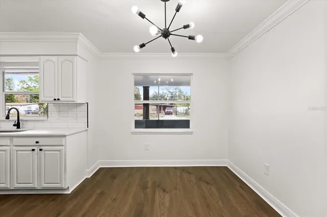 a view of empty room with window and wooden floor