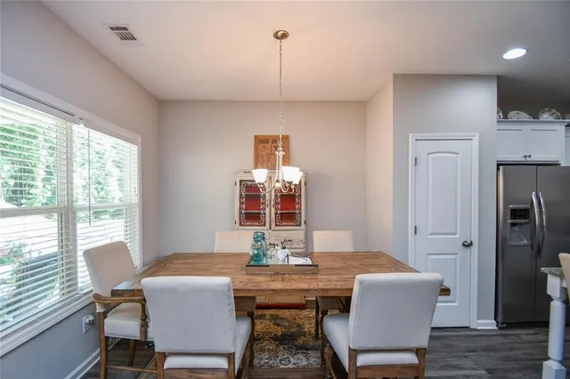 a kitchen with refrigerator and chairs