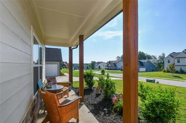 a view of a hallway with wooden floor and a bathroom
