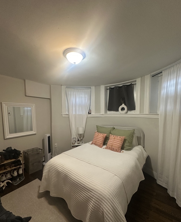 847 Beacon Street, Unit 9 Boston, MA 02215 - Photo 2 of 10 a bedroom with a bed and a dresser with wooden floor