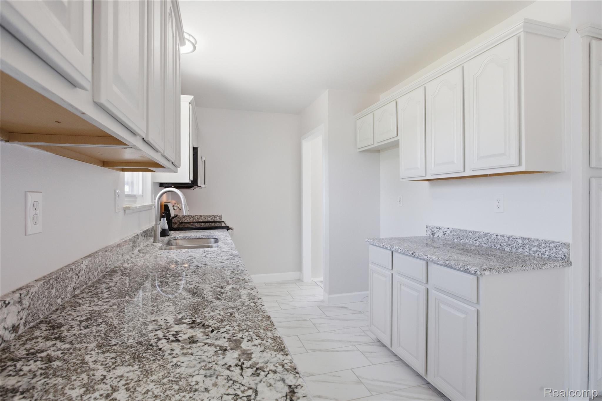 37257 Dundee Street Sterling Heights, MI 48310 - Photo 14 of 47 Kitchen featuring extensive light-toned cabinetry, light-colored countertops, a single basin sink with a high-arc faucet, a window above the sink, and tile flooring