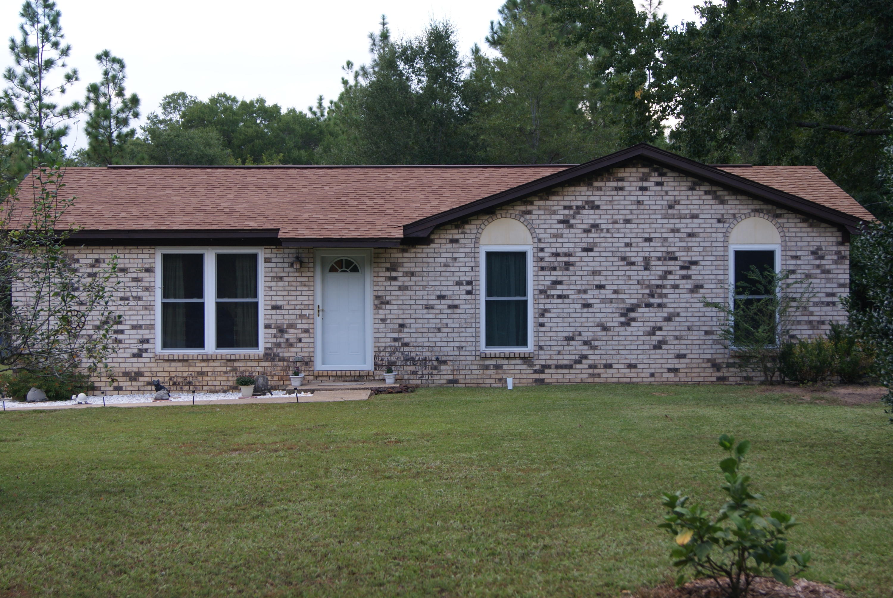 a front view of a house with a garden