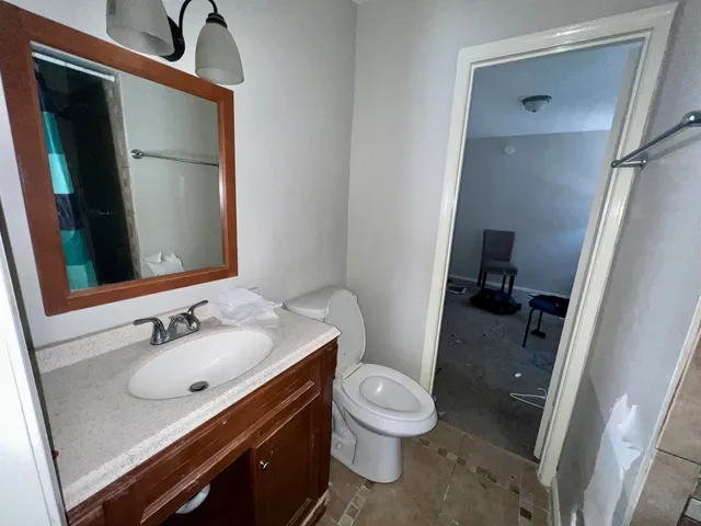 a bathroom with a toilet a sink a mirror and vanity
