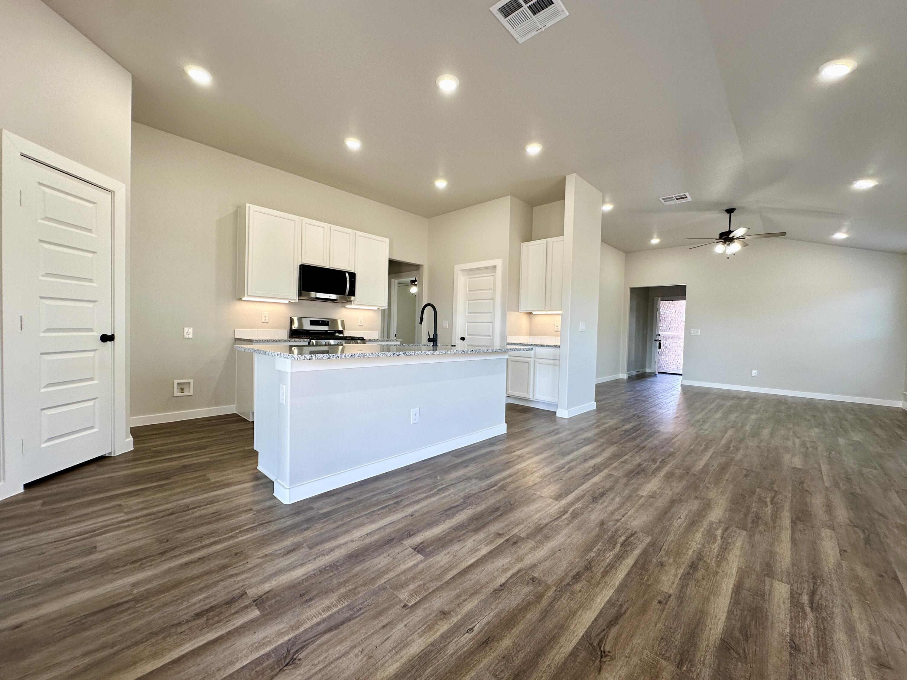 7449 28th Street Lubbock, TX 79407 - Photo 2 of 11 a large kitchen with cabinets and wooden floor
