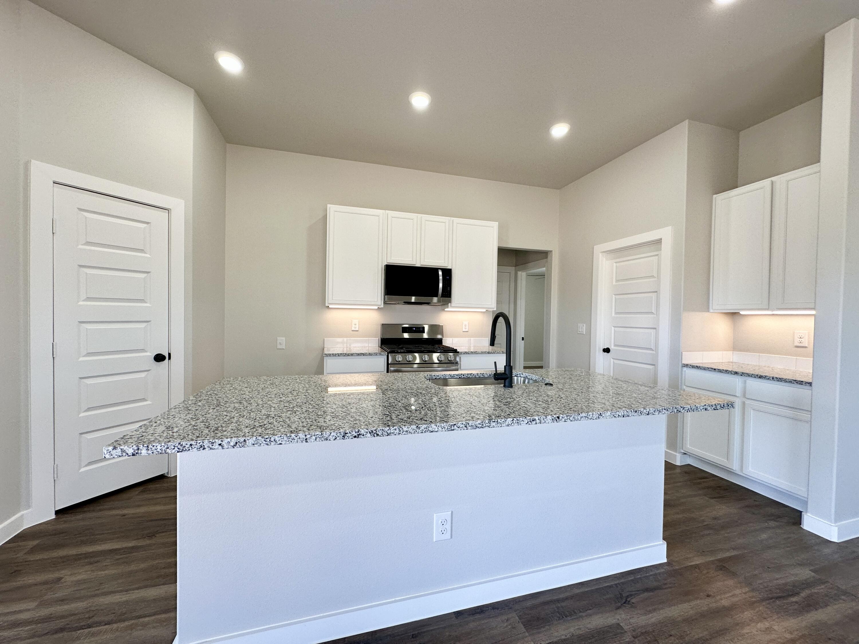 7449 28th Street Lubbock, TX 79407 - Photo 3 of 11 a view of living room with granite countertop cabinets and flat screen tv