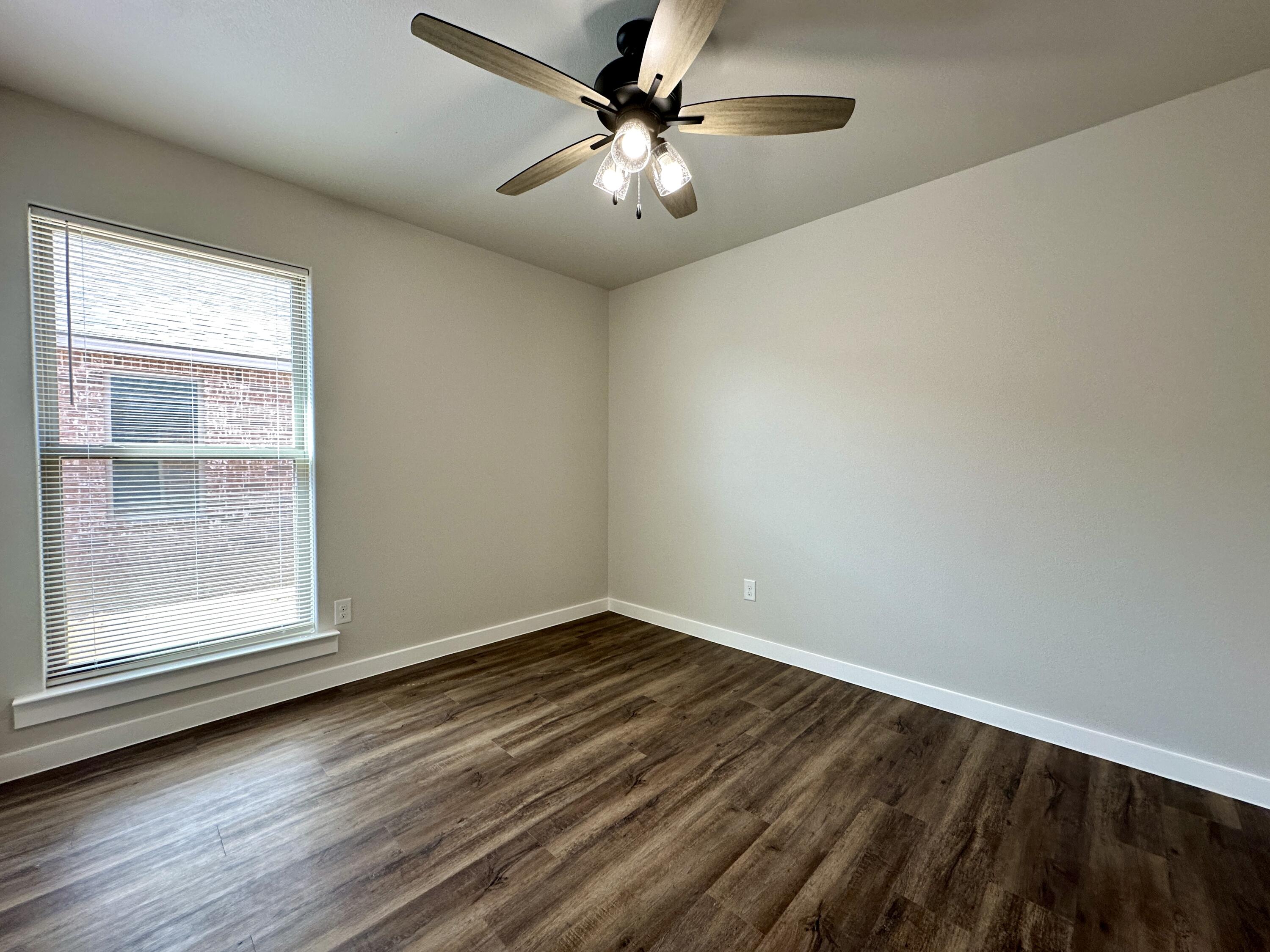 7449 28th Street Lubbock, TX 79407 - Photo 5 of 11 an empty room with a window and a fan