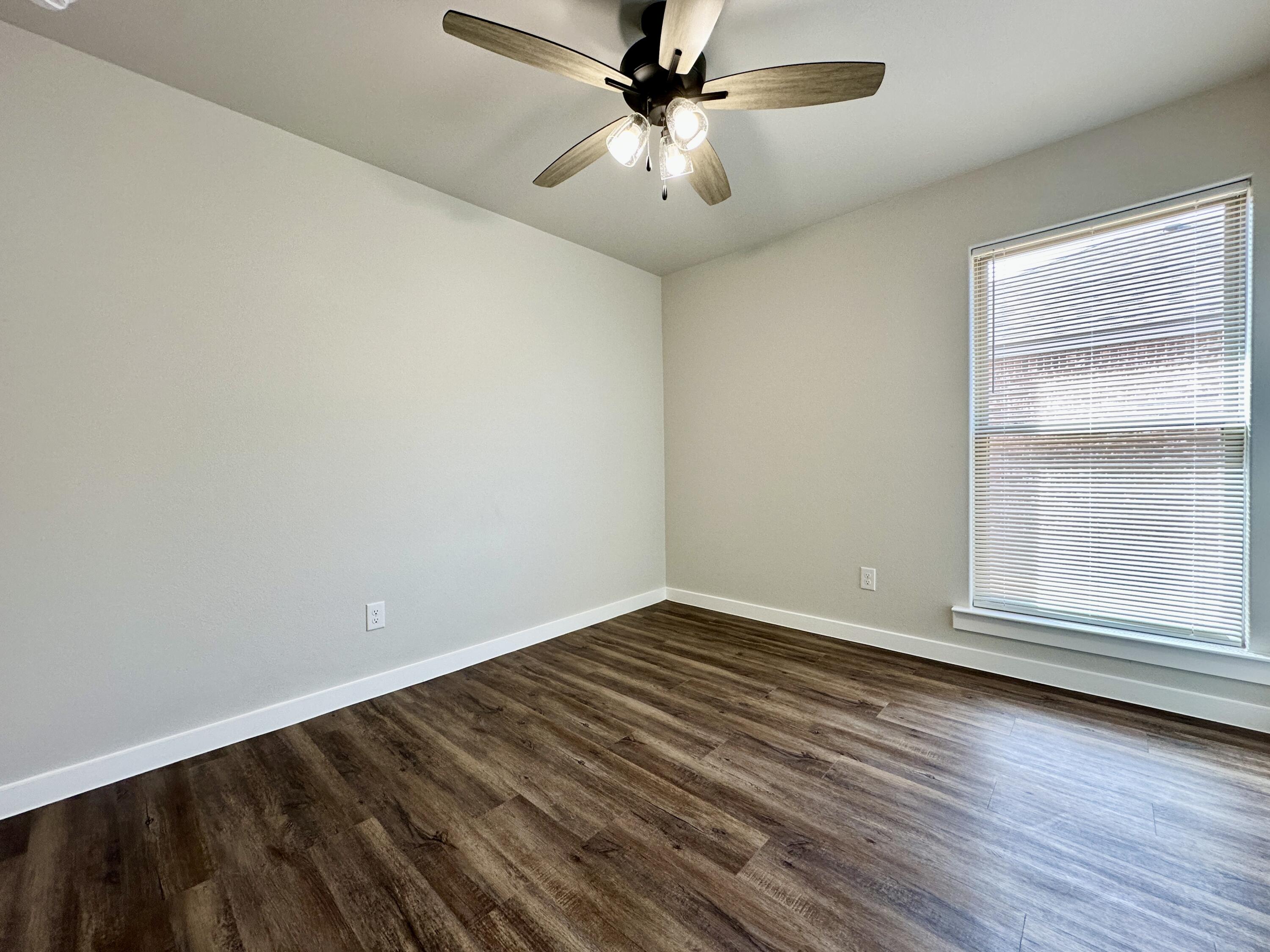 7449 28th Street Lubbock, TX 79407 - Photo 6 of 11 wooden floor in an empty room with a window