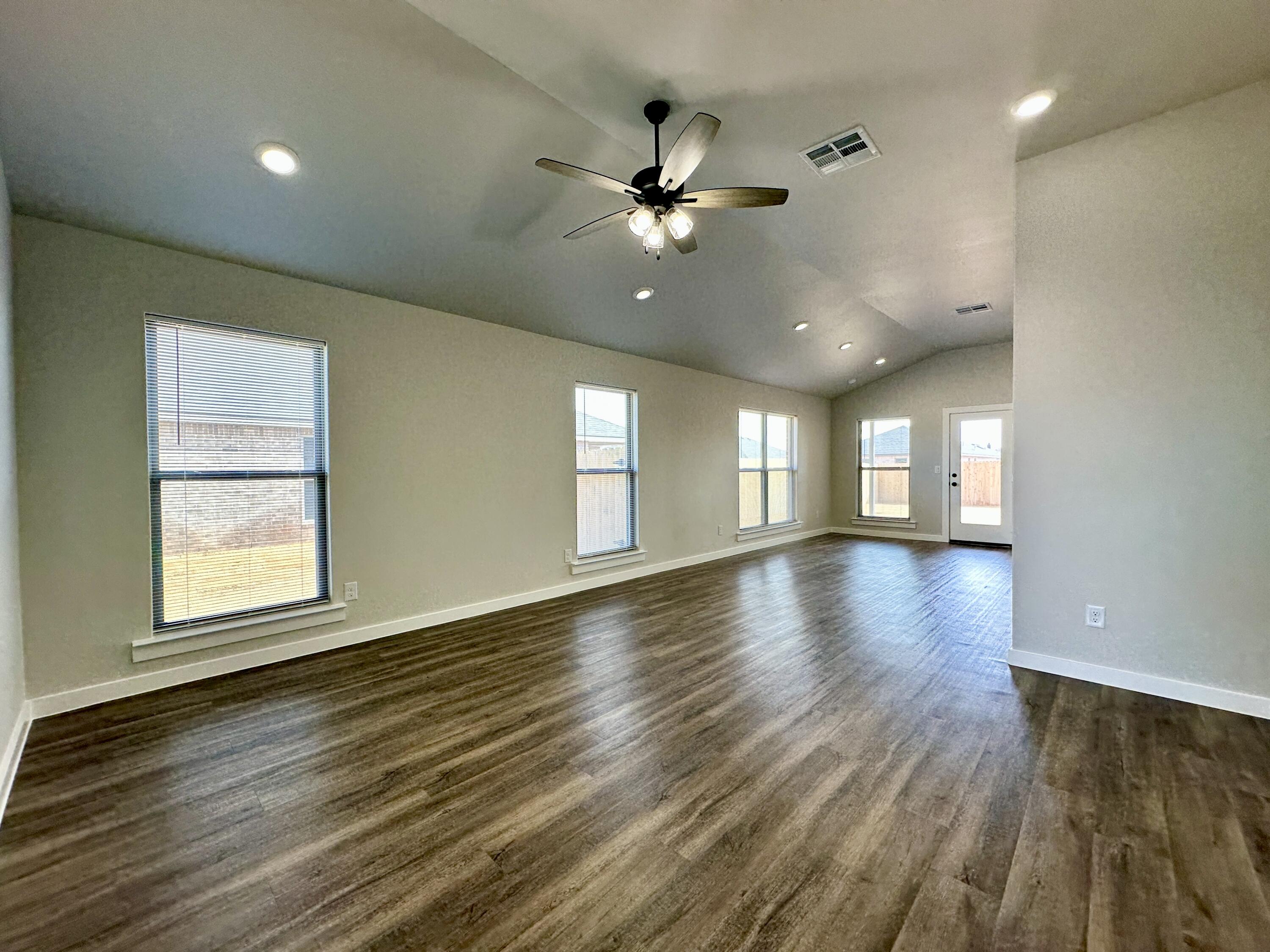 7449 28th Street Lubbock, TX 79407 - Photo 8 of 11 a view of an empty room with wooden floor and a window