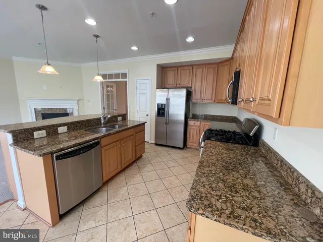 a kitchen with stainless steel appliances granite countertop a refrigerator and a sink