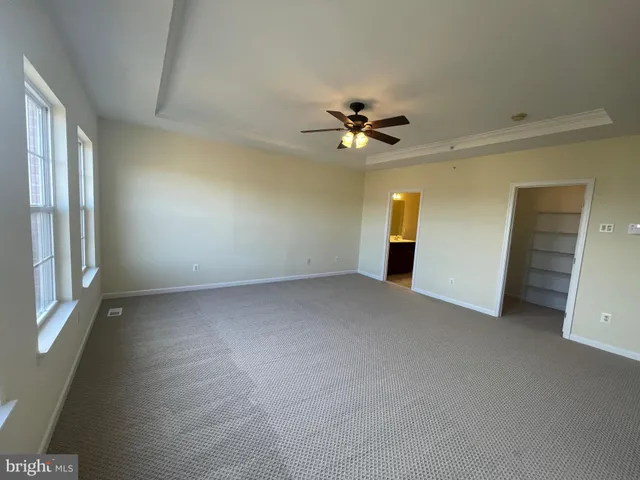 a view of an empty room with wooden floor and windows