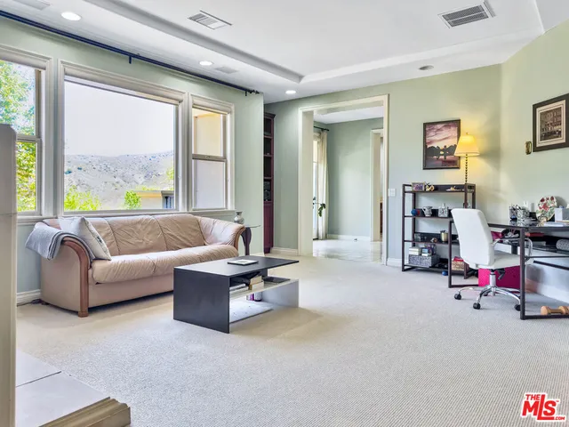 a living room with furniture and large windows