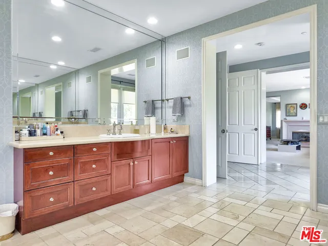 a bathroom with a granite countertop sink mirror and cabinets