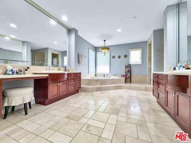 a large kitchen with stainless steel appliances a sink and cabinets
