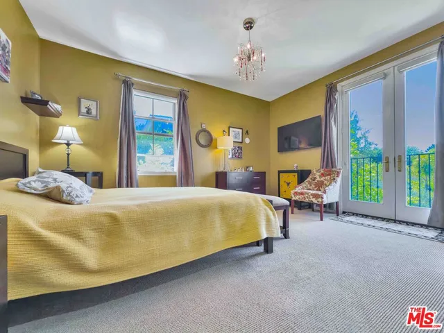 a bed sitting in a spacious bedroom next to a window