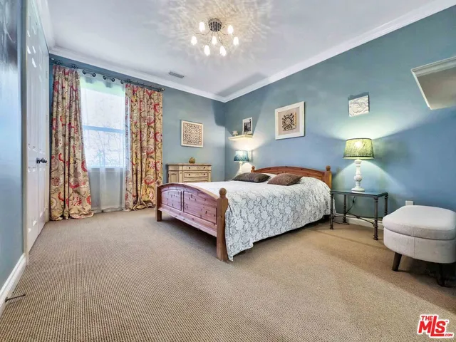 a bedroom with a bed couch and a window