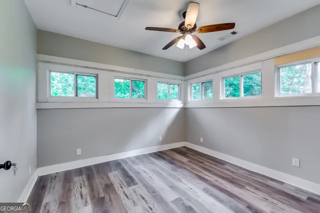 an empty room with a window and a ceiling fan