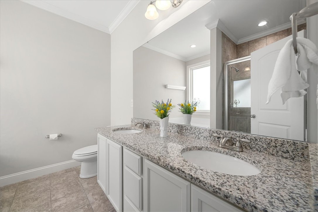 21 Barron Glenn Way Anderson, SC 29621 - Photo 30 of 48 This Primary Bathroom features a dual-sink vanity with granite countertops, large mirror, and a standalone shower.