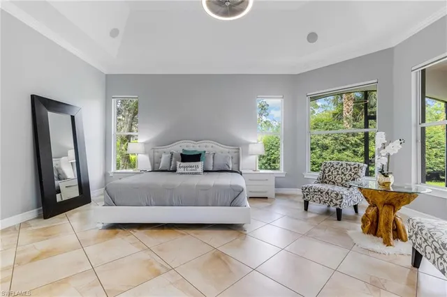 a bedroom with a bed and large windows