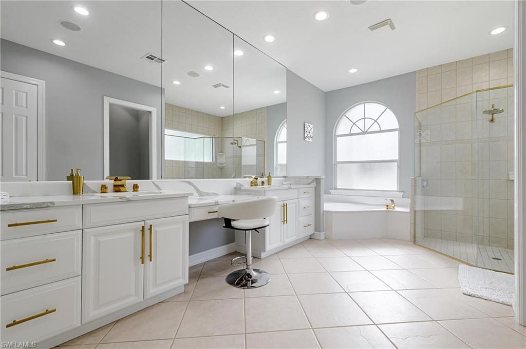 160 Logan Boulevard South Naples, FL 34119 - Photo 15 of 49 Bathroom featuring a garden tub, a stall shower, vanity, light tile patterned flooring, and healthy amount of natural light