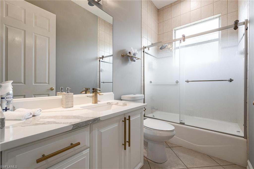 160 Logan Boulevard South Naples, FL 34119 - Photo 18 of 49 Bathroom featuring vanity, light tile patterned floors, and combined bath / shower with glass door
