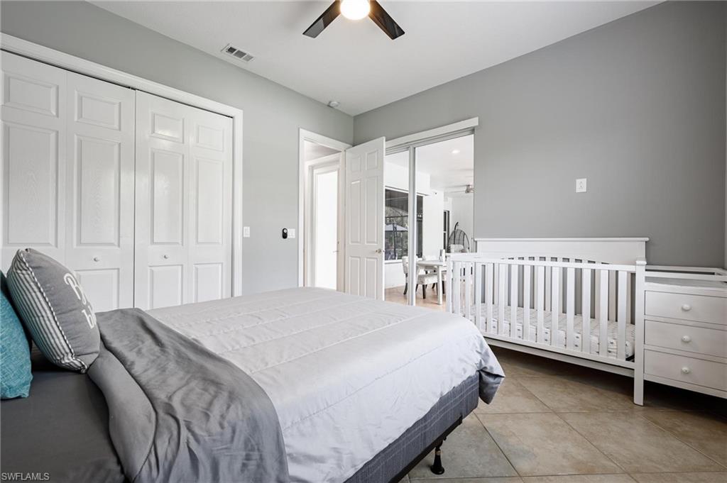160 Logan Boulevard South Naples, FL 34119 - Photo 21 of 49 Bedroom featuring a ceiling fan, light tile patterned floors, and a closet