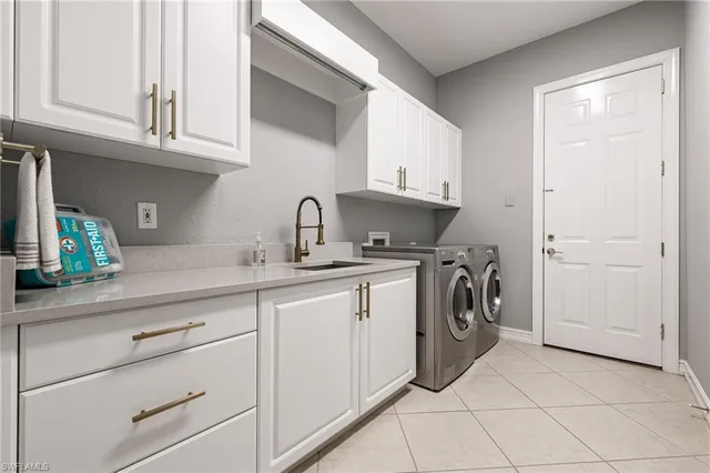 a utility room with cabinets washer and dryer