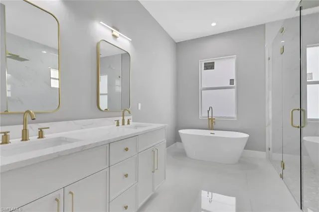 a bathroom with a double vanity sink mirror and bathtub