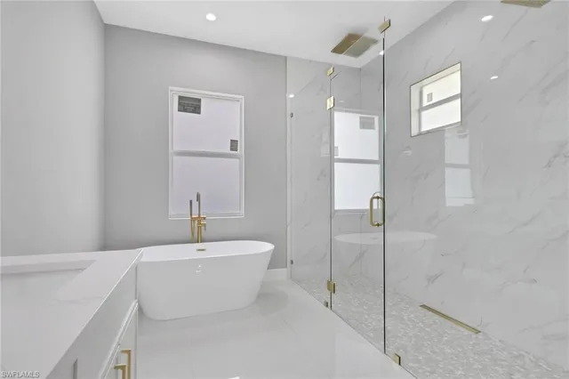 a bathroom with a white tub shower sink and a mirror