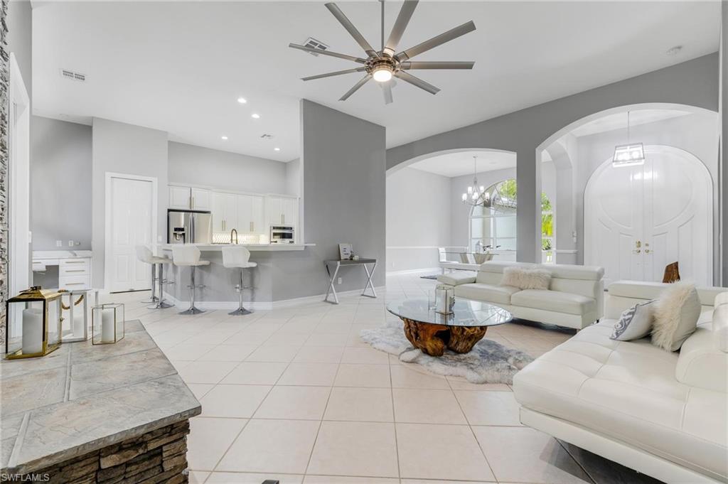 160 Logan Boulevard South Naples, FL 34119 - Photo 5 of 49 Living room featuring arched walkways, ceiling fan, a chandelier, light tile patterned floors, and recessed lighting
