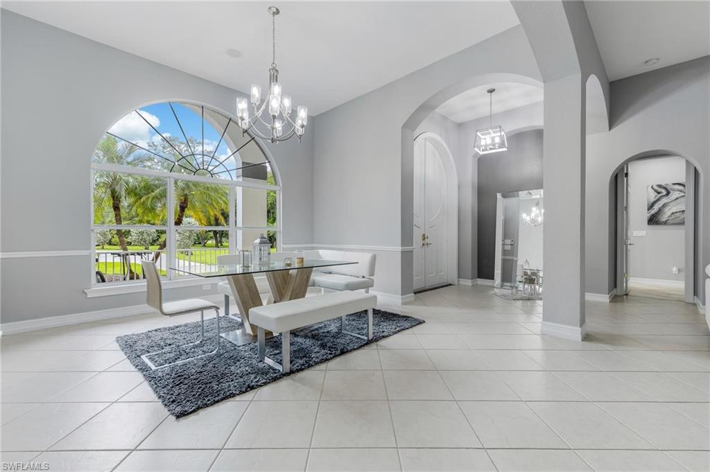 160 Logan Boulevard South Naples, FL 34119 - Photo 7 of 49 Dining room with a chandelier, arched walkways, and light tile patterned floors