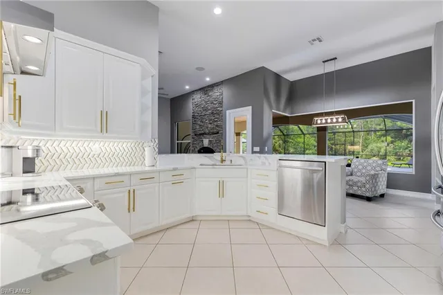 a kitchen with white cabinets and sink