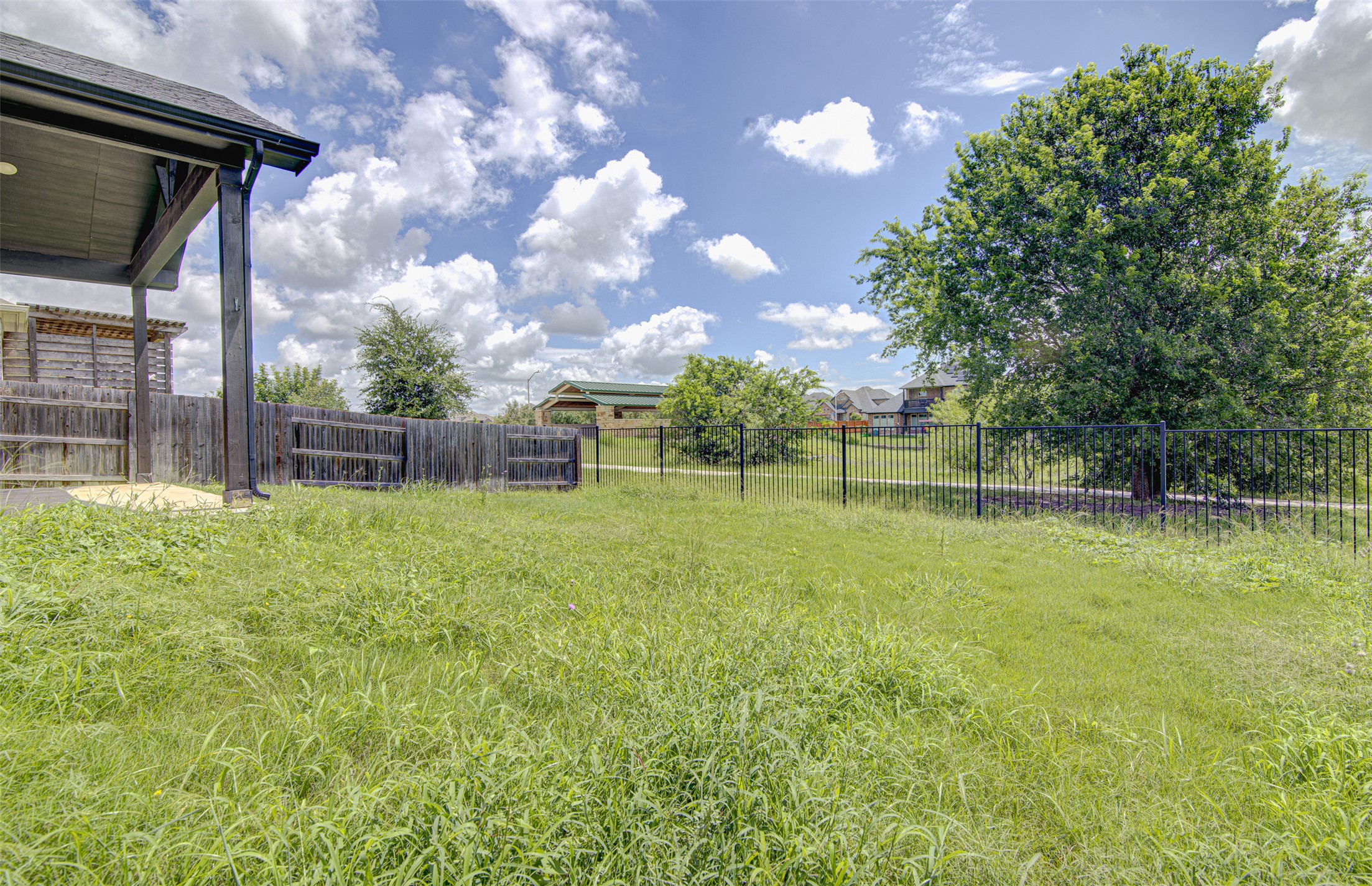774 Cherrystone Loop Buda, TX 78610 - Photo 34 of 38 A spacious yard with mature trees and perimeter fencing offers a private outdoor haven.