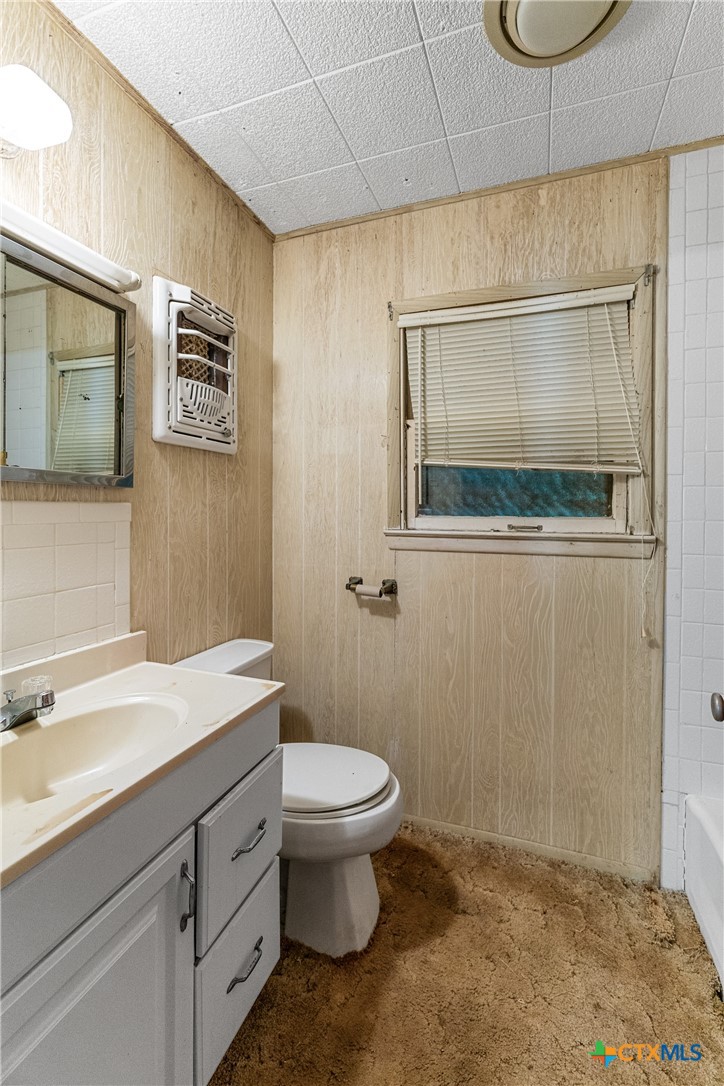 401 Kerr Street Edna, TX 77957 - Photo 16 of 23 a bathroom with a granite countertop sink mirror vanity and toilet