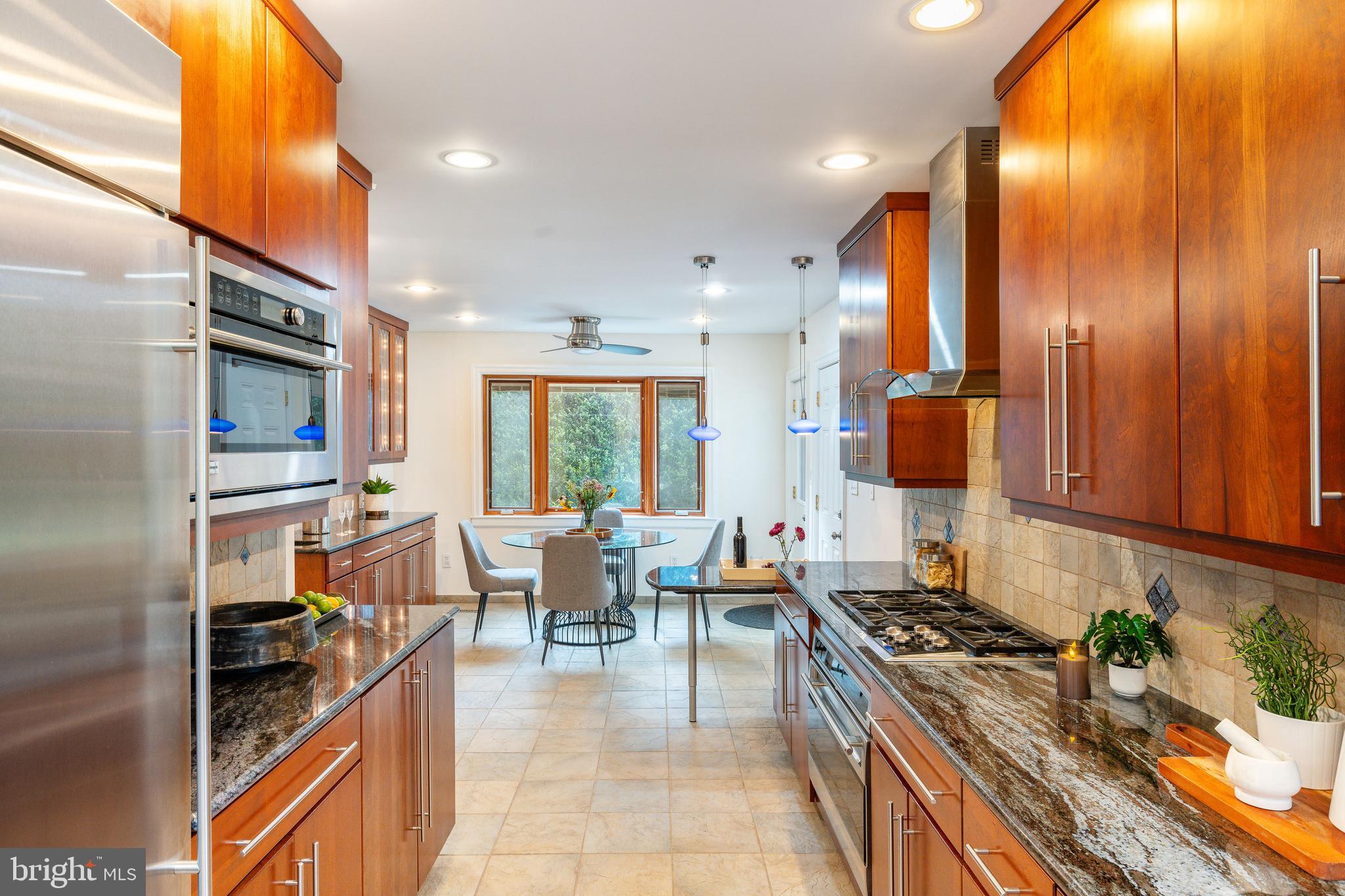 1419 County Line Road Bryn Mawr, PA 19010 - Photo 29 of 65 a kitchen with stainless steel appliances granite countertop a stove and a view of living room