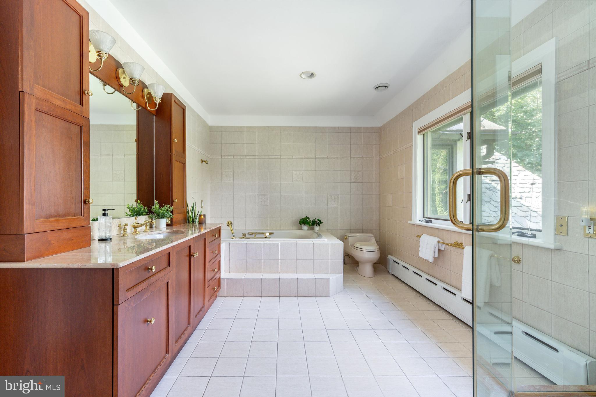 1419 County Line Road Bryn Mawr, PA 19010 - Photo 34 of 65 a bathroom with a double vanity sink a mirror and a bathtub