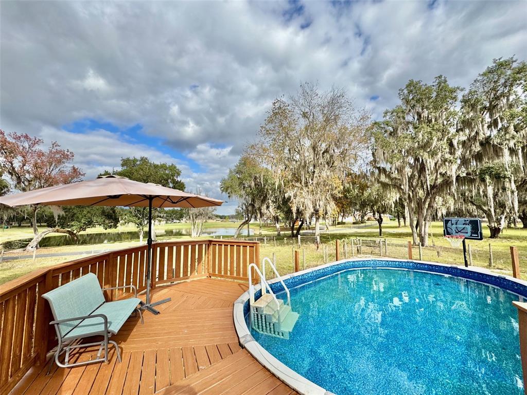 a view of a swimming pool with a deck and a garden