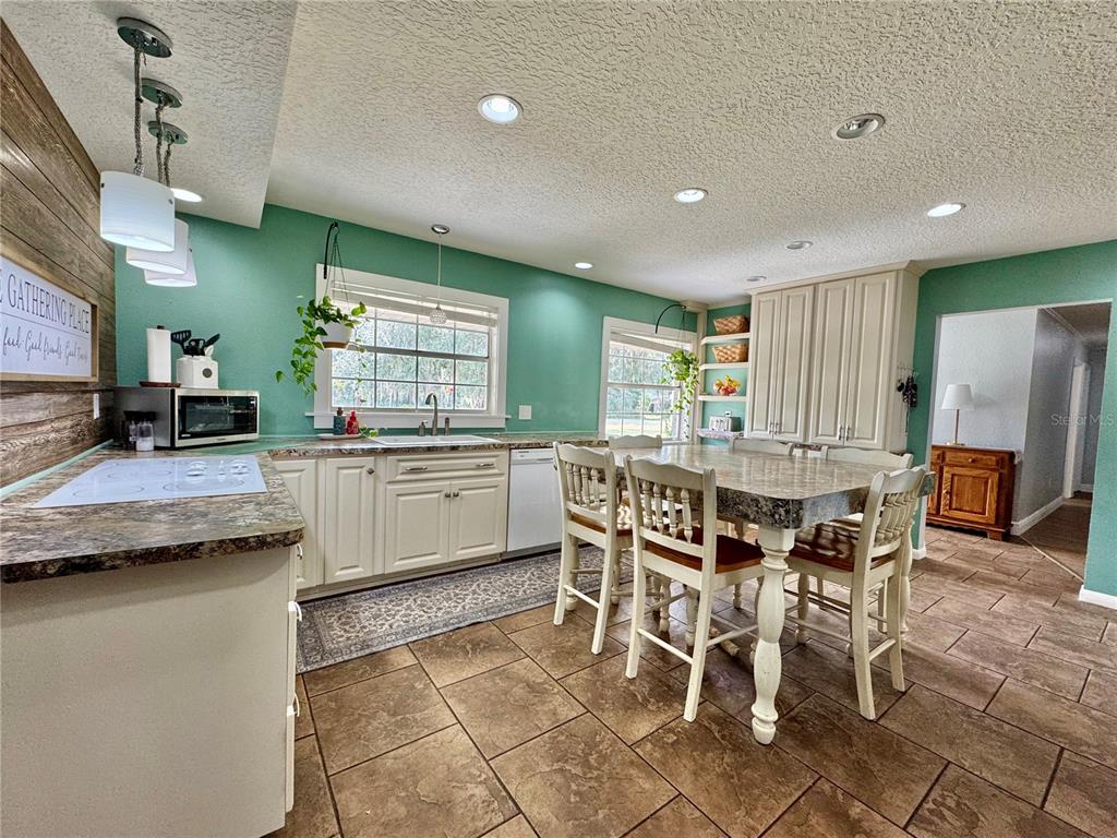 7625 East Misty Lane Inverness, FL 34450 - Photo 18 of 58 a kitchen with stainless steel appliances kitchen island granite countertop table chairs and a refrigerator