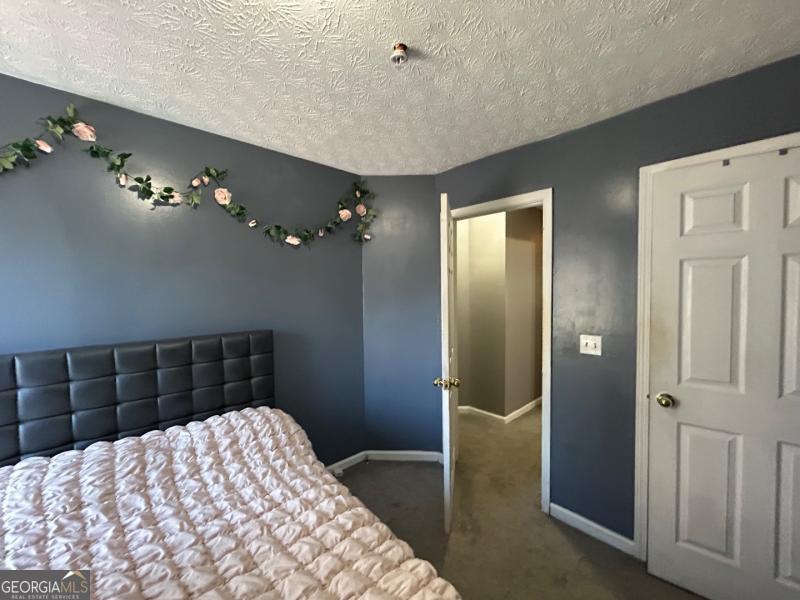 5099 Leeshire Trace Tucker, GA 30084 - Photo 17 of 26 a bedroom with a bed and a chandelier