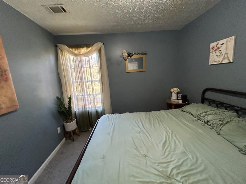 5099 Leeshire Trace Tucker, GA 30084 - Photo 21 of 26 a bedroom with a bed and a window