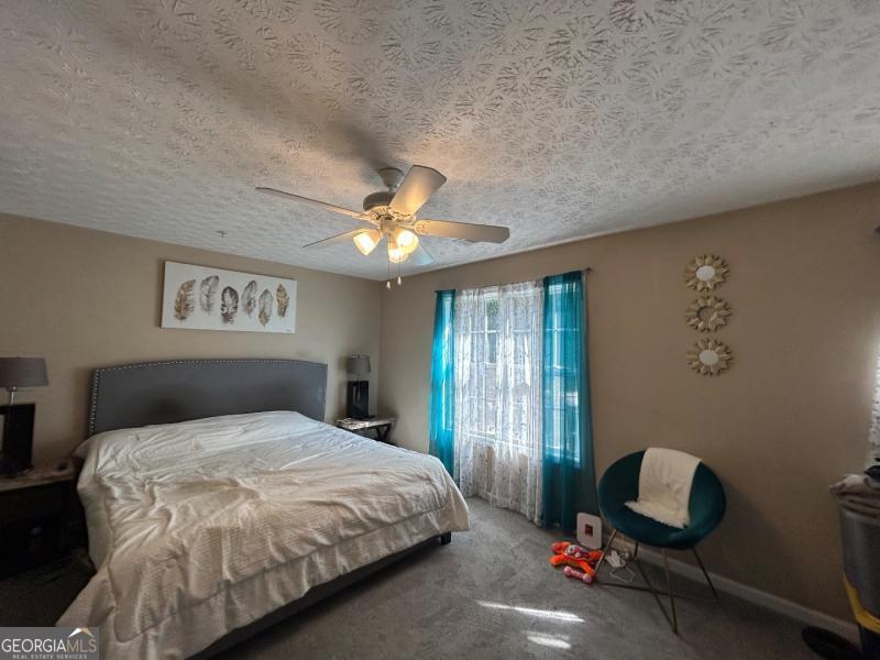 5099 Leeshire Trace Tucker, GA 30084 - Photo 3 of 26 a bedroom with a bed and a chandelier