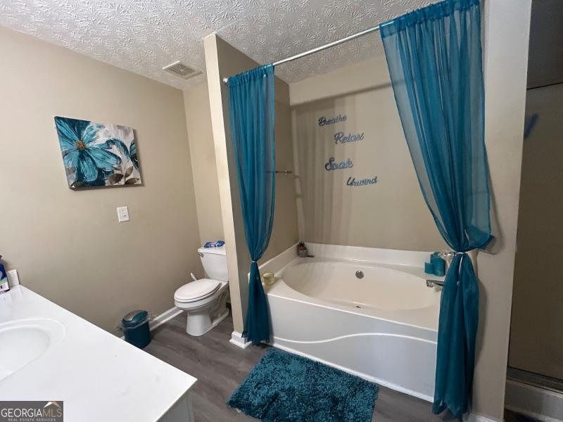 5099 Leeshire Trace Tucker, GA 30084 - Photo 4 of 26 a white bath tub sitting next to a white toilet and sink