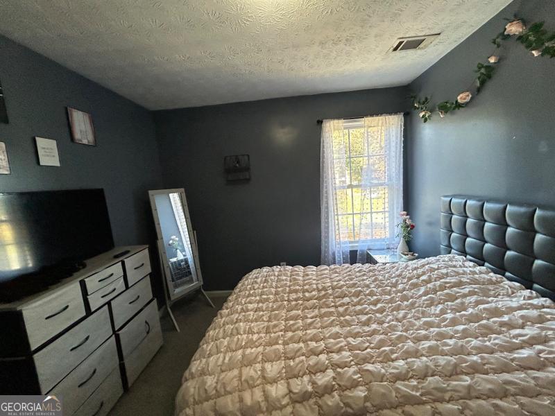 5099 Leeshire Trace Tucker, GA 30084 - Photo 8 of 26 a bedroom with a bed tv and a window