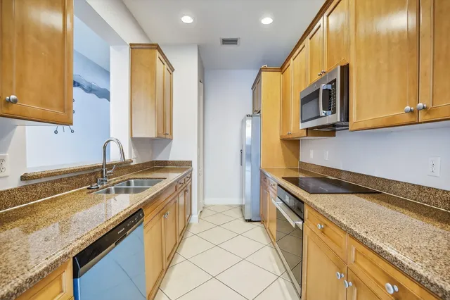 a kitchen with stainless steel appliances granite countertop a sink a stove and a microwave