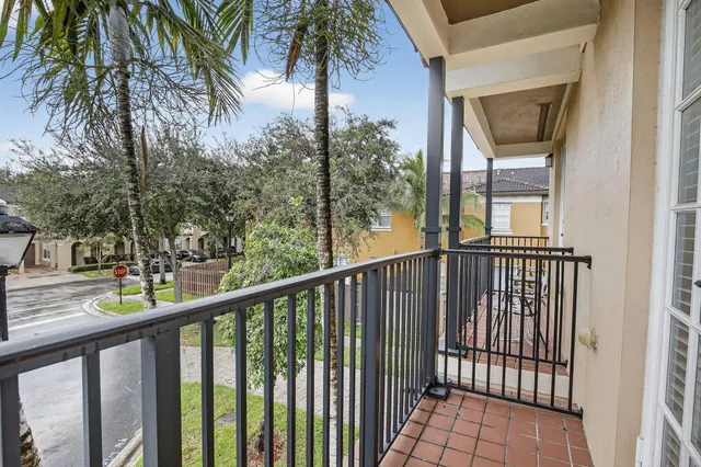 a view of a balcony with a floor to ceiling window and potted plants