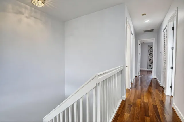 a view of a hallway with wooden floor and staircase