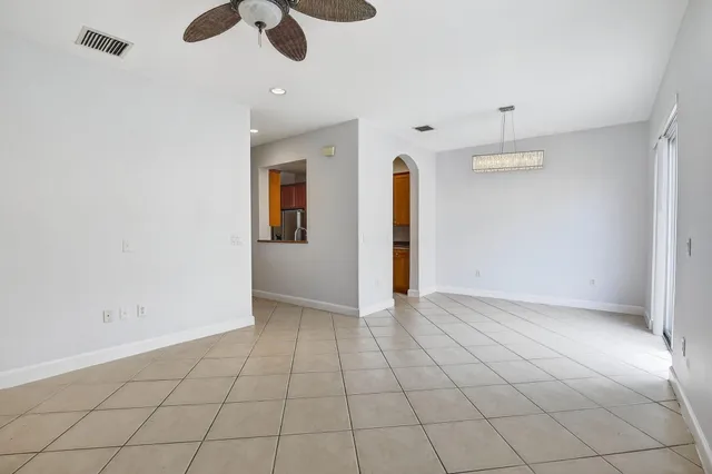 an empty room with a ceiling fan and carpet